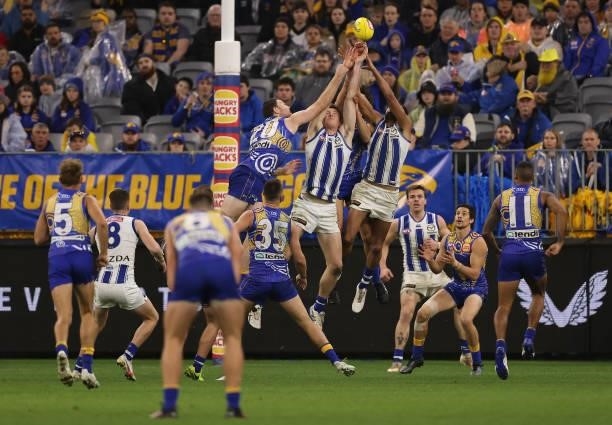 Nick Larkey and Tarryn Thomas of the Kangaroos contest for a mark against Jeremy McGovern of the Eagles during the round 17 AFL match between the...