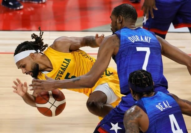 Patty Mills of the Australia Boomers is fouled by Kevin Durant of the United States during an exhibition game at Michelob Ultra Arena ahead of the...