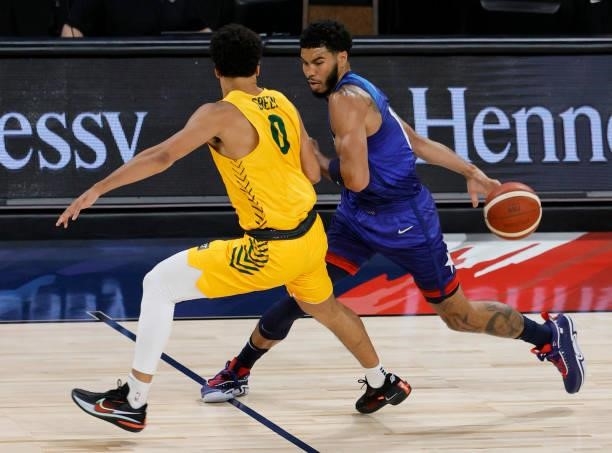 Jayson Tatum of the United States dribbles behind his back as he brings the ball up the court against Josh Green of the Australia Boomers during an...