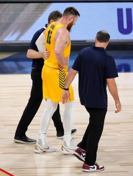 Aron Baynes of the Australia Boomers is helped off the court after he appeared to hurt his knee during an exhibition game against the United States...