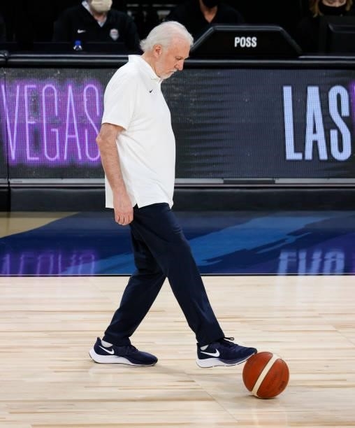 Head coach Gregg Popovich of the United States retrieves the ball during an exhibition game against the Australia Boomers at Michelob Ultra Arena...