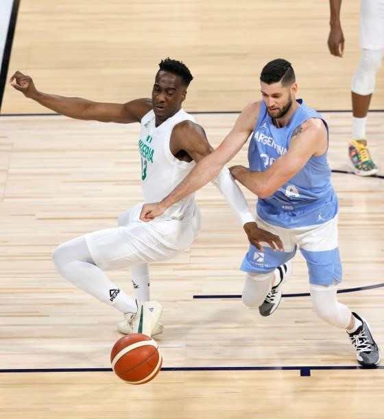 Miye Oni of Nigeria and Patricio Garino of Argentina go after a loose ball during an exhibition game at Michelob ULTRA Arena ahead of the Tokyo...