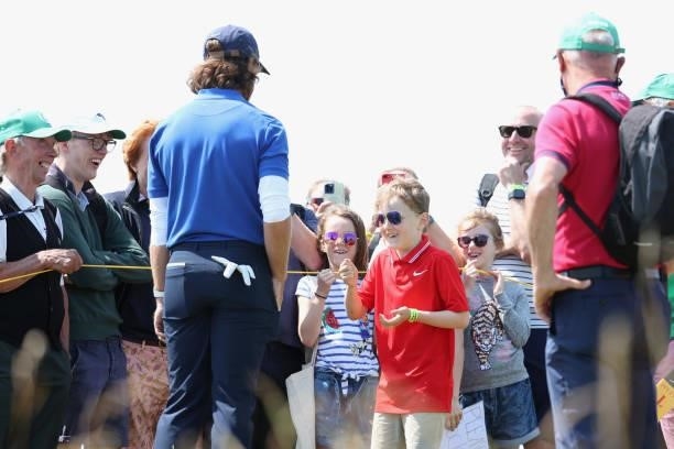 Tommy Fleetwood of England plays rock, paper, scissors with a spectator during a practice round for The 149th Open at Royal St George’s Golf Club on...