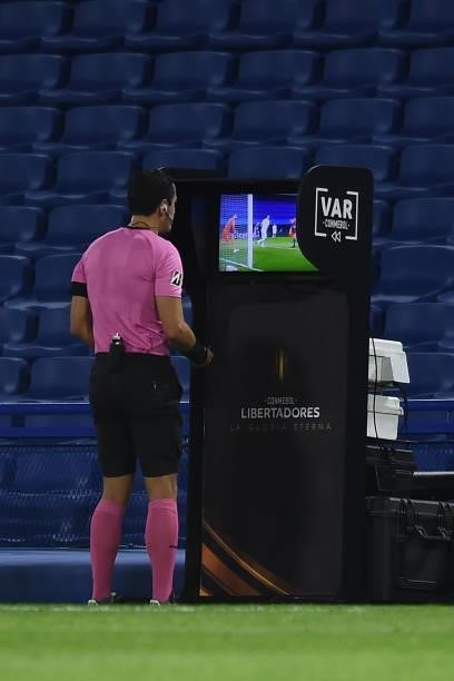 Referee Matias Rojas reviews a play on the VAR for a possible goal for Boca Juniors during a round of sixteen match between Boca Juniors and Atletico...
