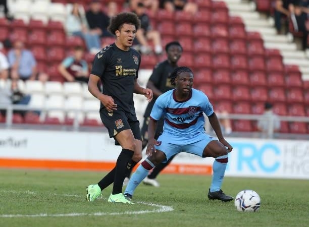 Shaun McWilliams of Northampton Town plays the ball watched by Keenan Appiah-Forson of West Ham United during the Pre-Season Friendly match between...