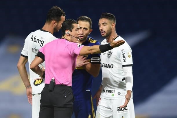 Carlos Izquierdoz of Boca Juniors and Júnior Alonso of Atletico MG argue with referee Andres Rojas during a round of sixteen match between Boca...