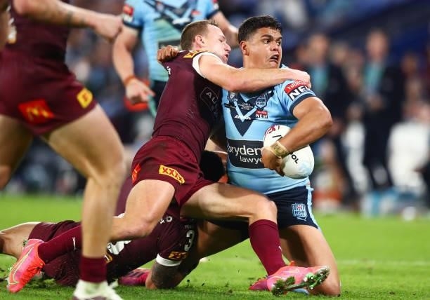 Latrell Mitchell of the Blues is tackled by Daly Cherry-Evans of the Maroons during game three of the 2021 State of Origin Series between the New...