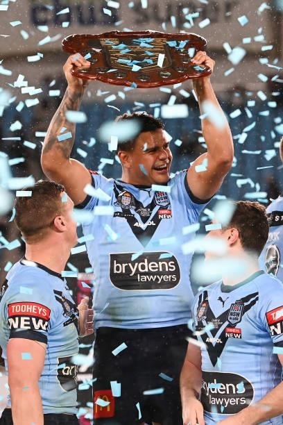 Latrell Mitchell of the Blues holds aloft the Origin trophy and celebrates with team mates after winning the series 2-1 after game three of the 2021...