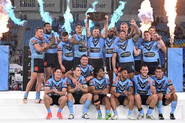James Tedesco of the Blues holds aloft the Origin trophy and celebrates with team mates after winning the series 2-1 after game three of the 2021...