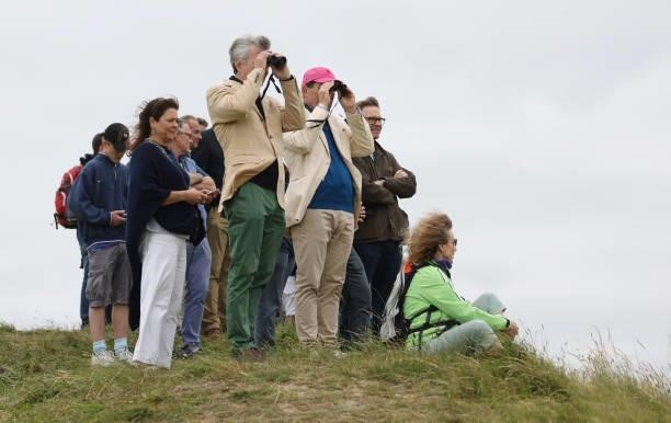 Spectators look through binoculars during a practice round for The 149th Open at Royal St George’s Golf Club on July 14, 2021 in Sandwich, England.