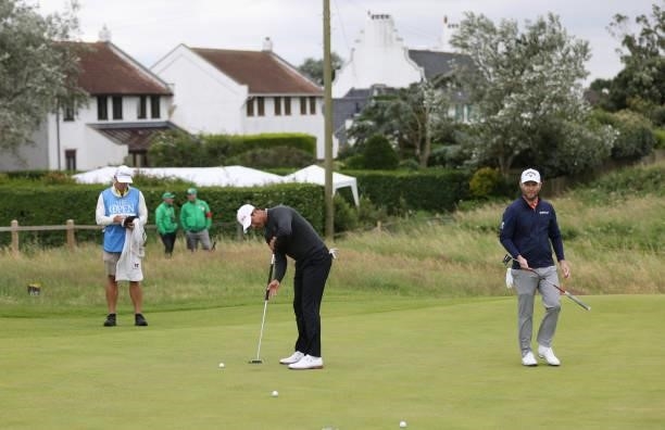 Adam Scott of Australia practices putting as Brandon Grace of South Africa looks on during a practice round for The 149th Open at Royal St George’s...