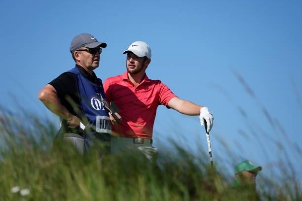 Sam Horsfield of England speaks with his caddie during Day One of The 149th Open at Royal St George’s Golf Club on July 15, 2021 in Sandwich, England.