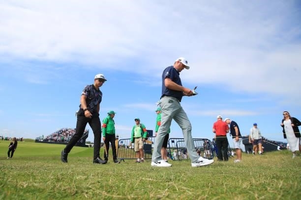 Garrick Higgo of South Africa and Jason Kokrak of the United States make their way off the ninth green during Day One of The 149th Open at Royal St...
