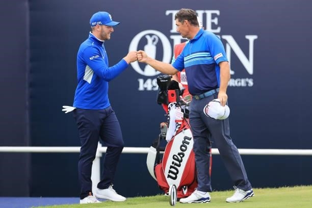 Sam Forgan of England and Padraig Harrington of Ireland bump fists on the 1st green during Day One of The 149th Open at Royal St George’s Golf Club...