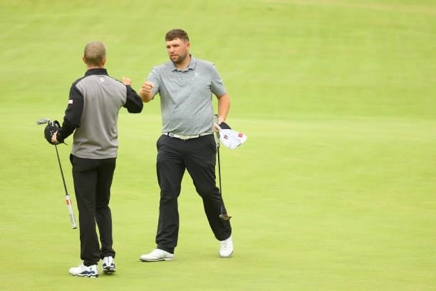 Marcus Kinhult of Sweden and Jack Senior of England interact after the 18th hole during Day One of The 149th Open at Royal St George’s Golf Club on...