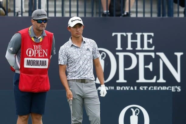 Collin Morikawa of the United States reacts with his caddie after he plays his shot from the first tee during Day One of The 149th Open at Royal St...