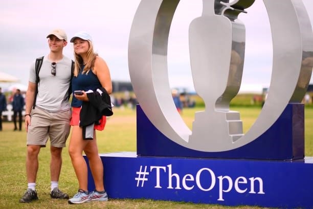 Spectators pose for photographs with Claret Jug signage during Day One of The 149th Open at Royal St George’s Golf Club on July 15, 2021 in Sandwich,...
