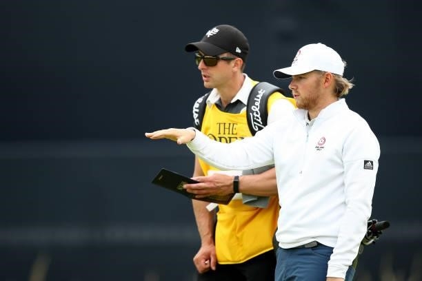 Amateur Joe Long of England talks with his caddie during Day One of The 149th Open at Royal St George’s Golf Club on July 15, 2021 in Sandwich,...