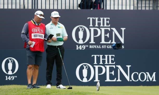 Charley Hoffman of the United States interacts with his caddie before playing his shot from the first tee during Day One of The 149th Open at Royal...