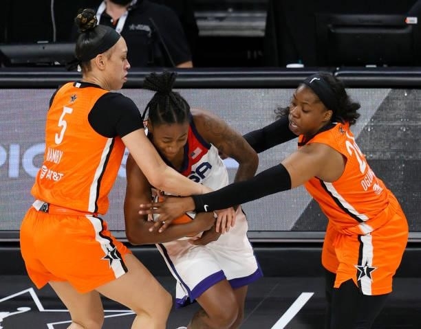 Dearica Hamby and Arike Ogunbowale of Team WNBA try to steal the ball from Jewell Loyd of the USA Women's National Team during the 2021 WNBA All-Star...