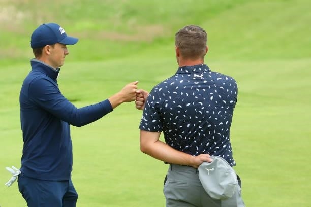 Jordan Spieth of the United States and Bryson DeChambeau of the United States bump fists on the green of the 18th hole during Day One of The 149th...