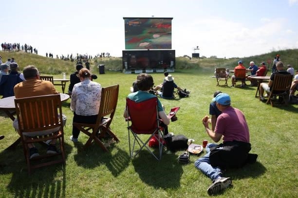 Spectators watch an LED screen during Day One of The 149th Open at Royal St George’s Golf Club on July 15, 2021 in Sandwich, England.