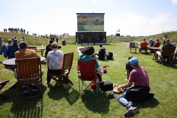 Spectators watch an LED screen during Day One of The 149th Open at Royal St George’s Golf Club on July 15, 2021 in Sandwich, England.