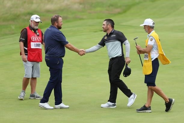 Defending champion Shane Lowry of Ireland shakes hands with Louis Oosthuizen of South Africa during Day One of The 149th Open at Royal St George’s...