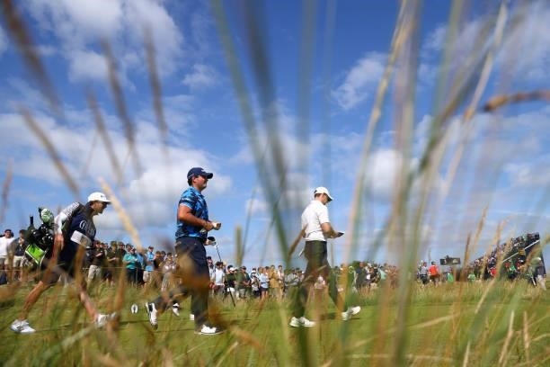 Rory McIlroy of Northern Ireland and Patrick Reed of The United States walk from the 1st tee during Day One of The 149th Open at Royal St George’s...