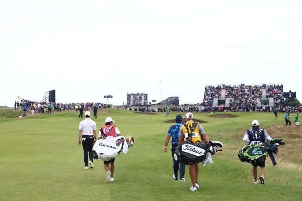 Rory McIlroy of Northern Ireland, Patrick Reed of The United States and Cameron Smith of Australia walk on the 1st hole during Day One of The 149th...