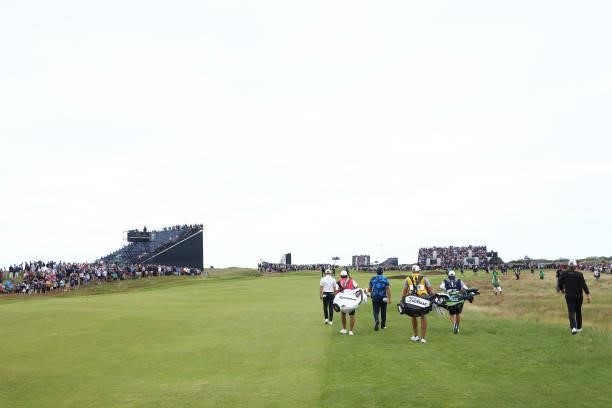 Rory McIlroy of Northern Ireland, Patrick Reed of The United States and Cameron Smith of Australia walk on the 1sthole during Day One of The 149th...