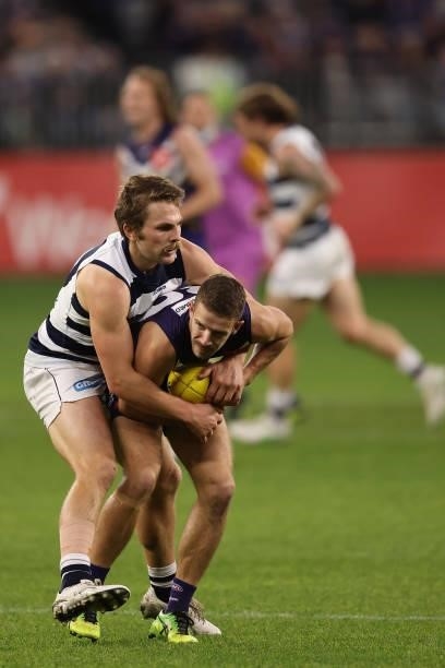 Tom Atkins of the Cats tackles Sam Switkowski of the Dockers during the round 18 AFL match between the Fremantle Dockers and Geelong Cats at Optus...