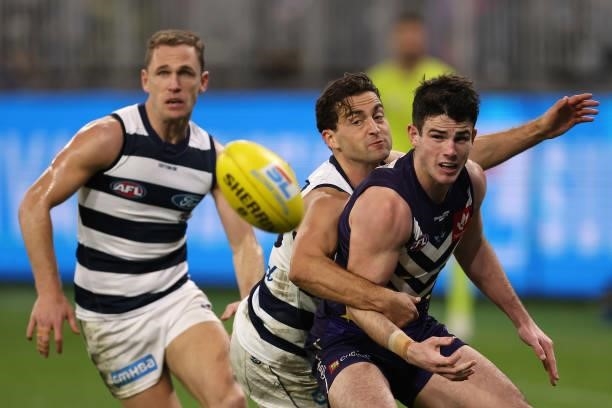 Andrew Brayshaw of the Dockers gets his handball away before under pressure from Luke Dahlhaus of the Cats during the round 18 AFL match between the...