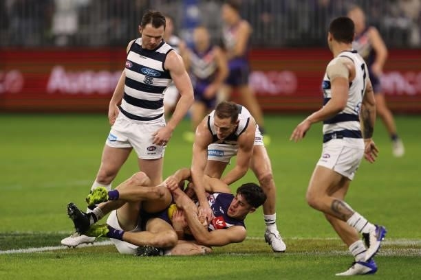 Adam Cerra of the Dockers is tackled by Mark Blicavs of the Cats during the round 18 AFL match between the Fremantle Dockers and Geelong Cats at...