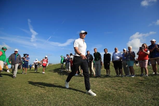 Rory McIlroy of Northern Ireland walks off the eighth green as fans look on during Day One of The 149th Open at Royal St George’s Golf Club on July...