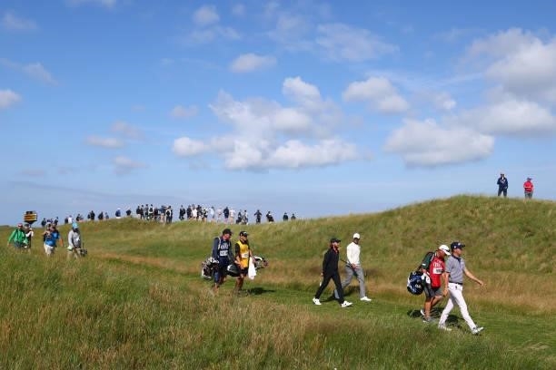 Justin Thomas of United States, Tommy Fleetwood of England and Adam Scott of Australia walk on the 6th hole during Day One of The 149th Open at Royal...
