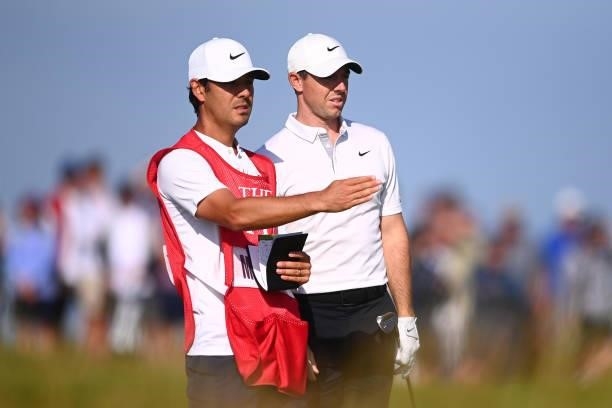 Rory McIlroy of Northern Ireland and caddie Harry Diamond look on during Day One of The 149th Open at Royal St George’s Golf Club on July 15, 2021 in...