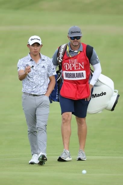 Collin Morikawa of United States and caddie walk on the 18th hole during Day One of The 149th Open at Royal St George’s Golf Club on July 15, 2021 in...