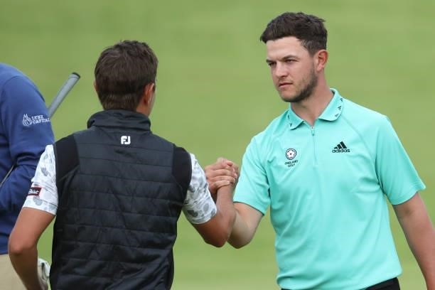 Jason Scrivener of Australia shakes hands with Sam Bairstow of England on the 18th green during Day One of The 149th Open at Royal St George’s Golf...