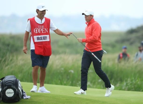 Rory McIlroy of Northern Ireland reacts as he hands his club to caddie Harry Diamond on the 14th green during Day One of The 149th Open at Royal St...