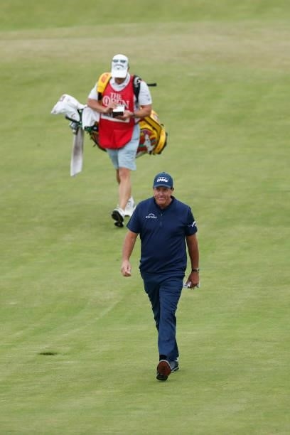 Phil Mickelson of the United States and caddie Tim Mickelson walk the 18th hole during Day One of The 149th Open at Royal St George’s Golf Club on...