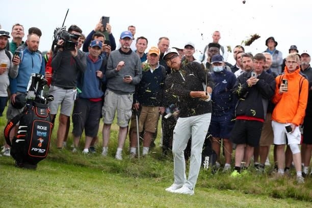 Rickie Fowler of the United States plays his second shot from the rough on the 17th hole as a gallery of fans look on during Day One of The 149th...