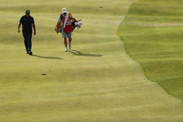 Phil Mickelson of the United States and caddie Tim Mickelson walk the 15th hole during Day One of The 149th Open at Royal St George’s Golf Club on...