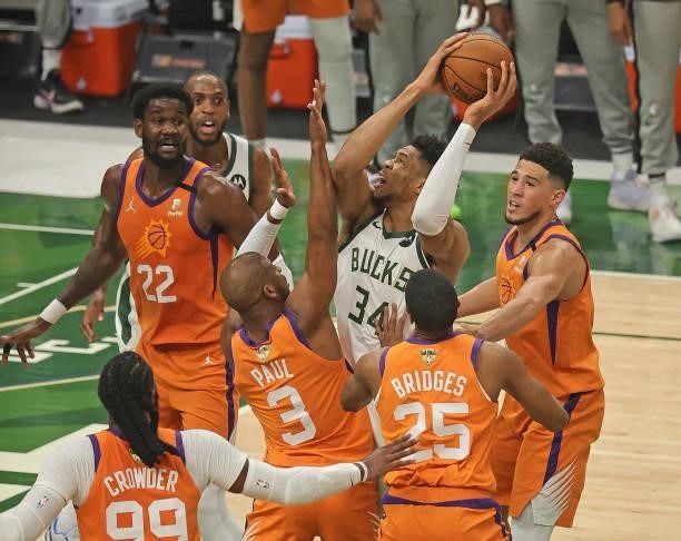 Giannis Antetokounmpo of the Milwaukee Bucks tries to get off a shot under pressure from Jae Crowder, Deandre Ayton, Chris Paul, Mikal Bridges and...