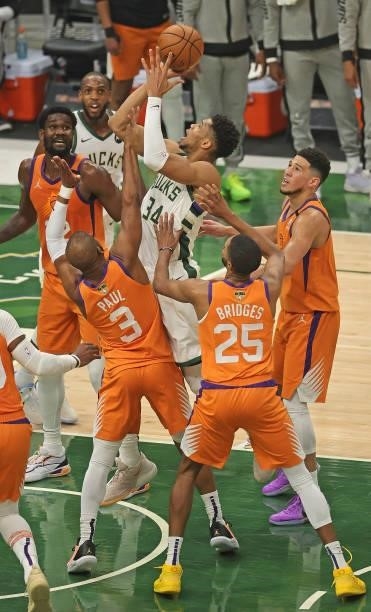 Giannis Antetokounmpo of the Milwaukee Bucks tries to get off a shot under pressure from Deandre Ayton, Chris Paul, Mikal Bridges and Devin Booker of...