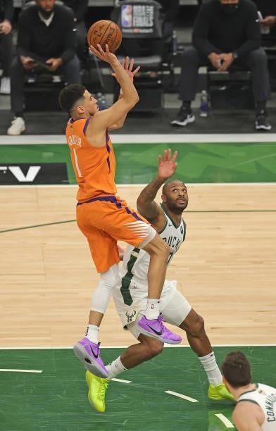 Devin Booker of the Phoenix Suns shoots over P.J. Tucker of the Milwaukee Bucks at Fiserv Forum on July 14, 2021 in Milwaukee, Wisconsin. The Bucks...
