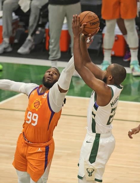 Khris Middleton of the Milwaukee Bucks shoots over Jae Crowder of the Phoenix Suns at Fiserv Forum on July 14, 2021 in Milwaukee, Wisconsin. The...