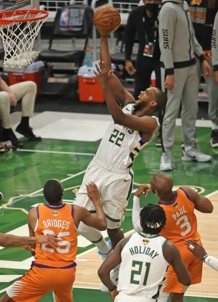 Khris Middleton of the Milwaukee Bucks shoots over Mikal Bridges and Chris Paul of the Phoenix Suns at Fiserv Forum on July 14, 2021 in Milwaukee,...
