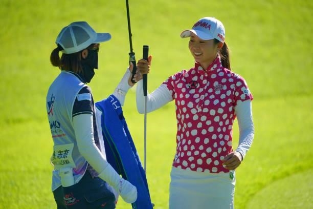 Shina Kanazawa of Japan fist bumps with her caddie after the birdie on the 17th green during first round of the GMO Internet Ladies Samantha Thavasa...