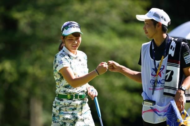 Hikari Tanabe of Japan fist bumps with her caddie after holing out with the birdie on the 9th green during first round of the GMO Internet Ladies...